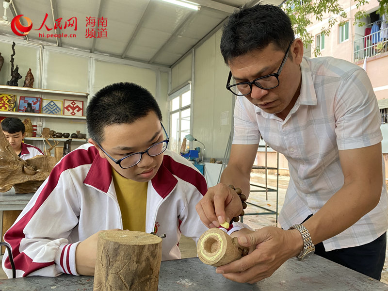 蒋友锋教学生雕刻木料。人民网 樊欢迪摄
