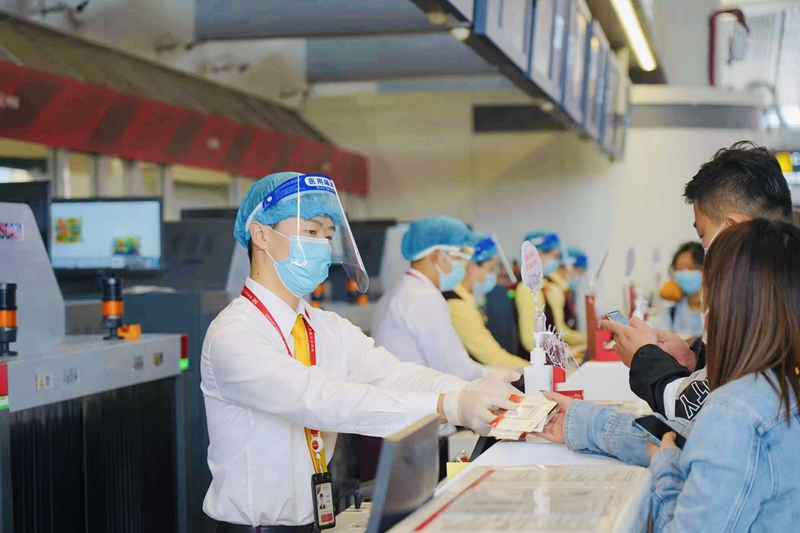 工作人员佩戴面罩为旅客值机。美兰机场供图