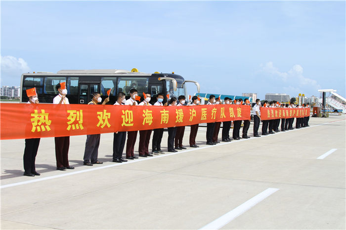 工作人员手举横幅，欢迎援沪医疗队员归来。三亚凤凰国际机场供图