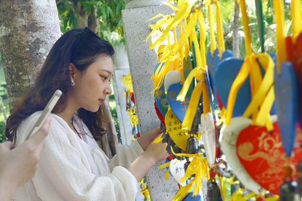 6月29日，游人在三亚南山文化旅游区系心愿牌祈福