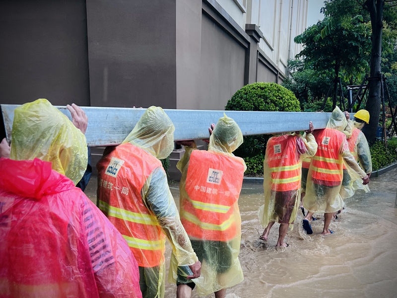 建设者们冒雨施工。梁惠摄