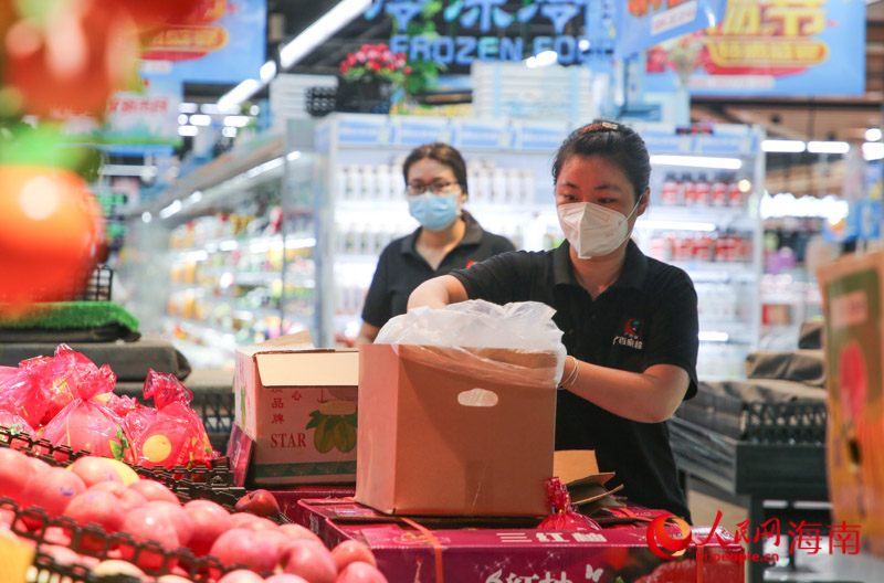 超市工作人员正在将货物上架。人民网 牛良玉摄