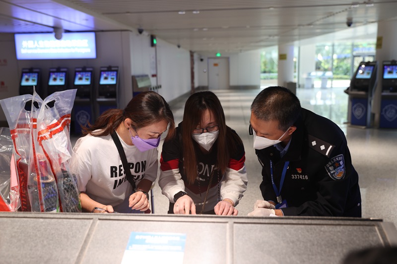 海口美兰边检站民警正在指导入境旅客填写外国人登记卡。朱晨鹏摄