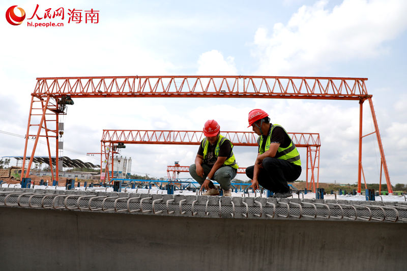 在阳江北互通施工现场，工人正检查预制梁。 人民网 孟凡盛摄