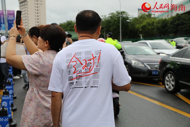 在海南华侨中学（高中部）考点，家长穿着印有加油鼓气字样的衣服前来为考生加油。人民网记者 孟凡盛摄