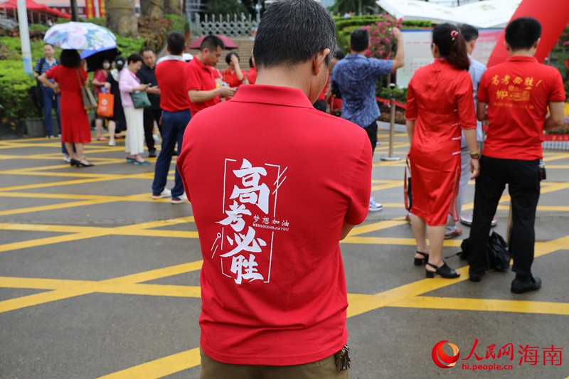 在海南华侨中学（高中部）考点，不少家长穿着红色衣服前来为考生加油。人民网记者 孟凡盛摄