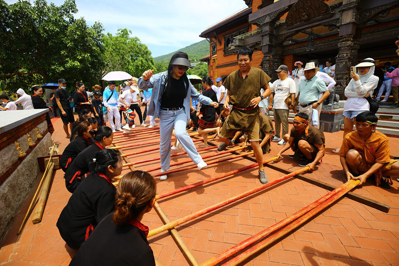 6月10日，三亚南山非遗节现场，游客体验国家非遗项目《打柴舞》。陈文武摄