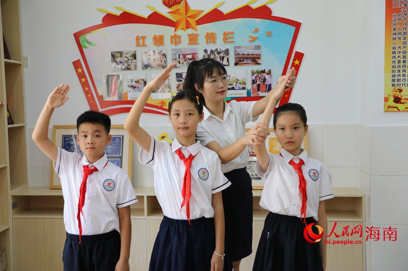 黄雨媚老师纠正同学行中国少年先锋队队礼的姿势。 人民网记者 孟凡盛摄
