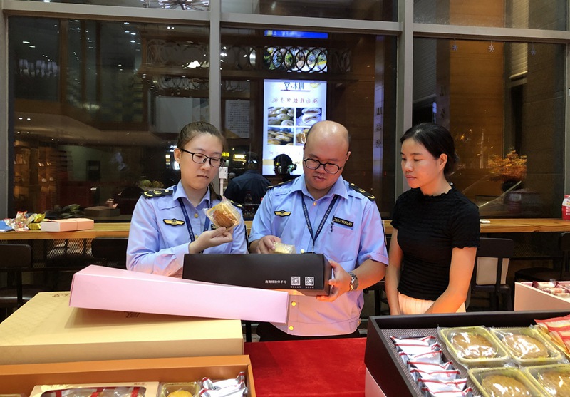 市场监督管理局工作人员正在销售店内检查月饼包装情况。海南省市场监督管理局供图