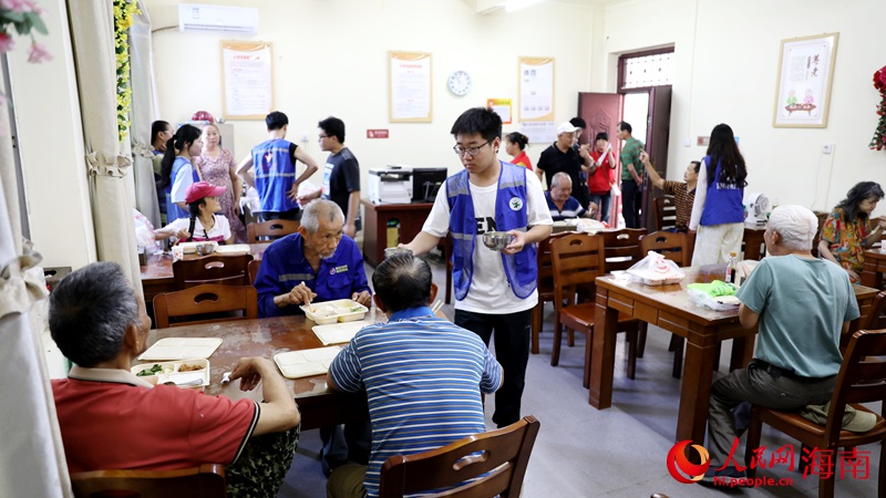 志愿者正在给用餐的老人盛汤。人民网记者 符武平摄