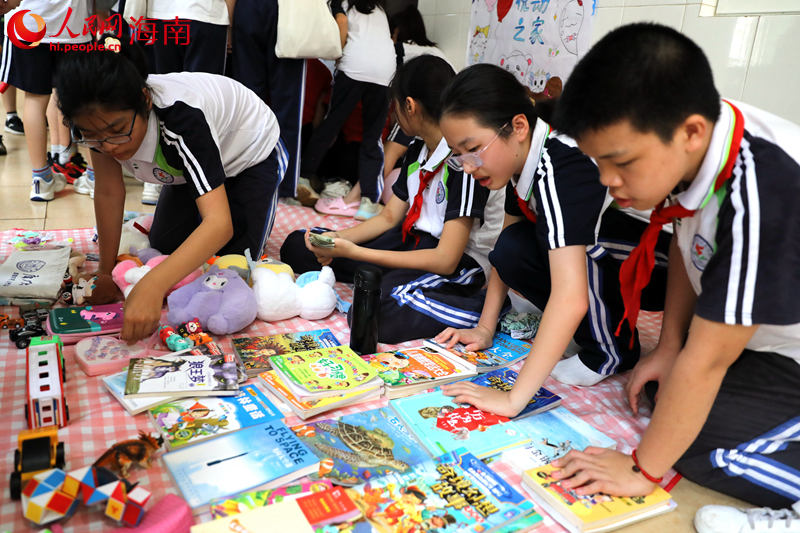 5月31日，海口市第二十五小学举办公益跳蚤市场活动，学生们对课外书籍进行售卖。 人民网记者 孟凡盛摄