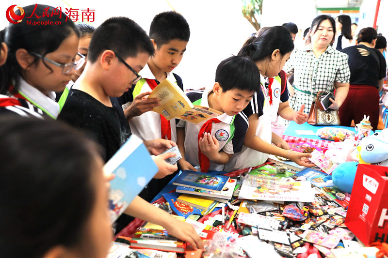 5月31日，海口市第二十五小学举办公益跳蚤市场活动，学生们挑选购买自己喜爱的物品。 人民网记者 孟凡盛摄