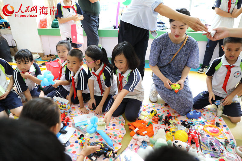 5月31日，海口市第二十五小学举办公益跳蚤市场活动，学生们挑选购买自己喜爱的物品。 人民网记者 孟凡盛摄