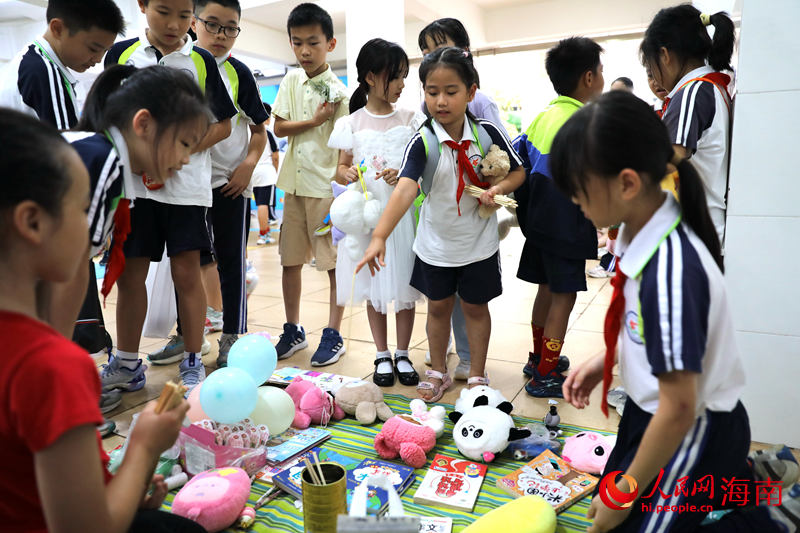 5月31日，在海口市第二十五小学公益跳蚤市场上，学生通过做游戏来赢得喜爱的物品。 人民网记者 孟凡盛摄