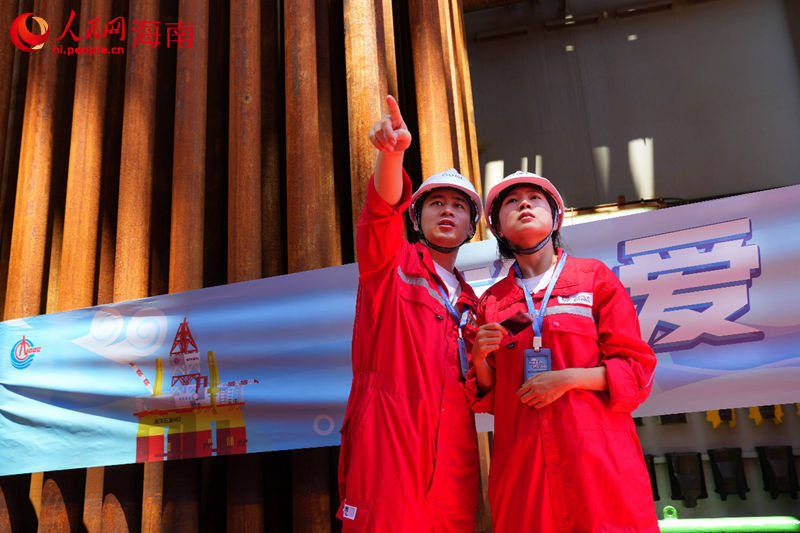 员工正跟家人详细介绍平台司钻房功能及作用，讲述在平台上工作的点滴故事。人民网记者孟凡盛摄