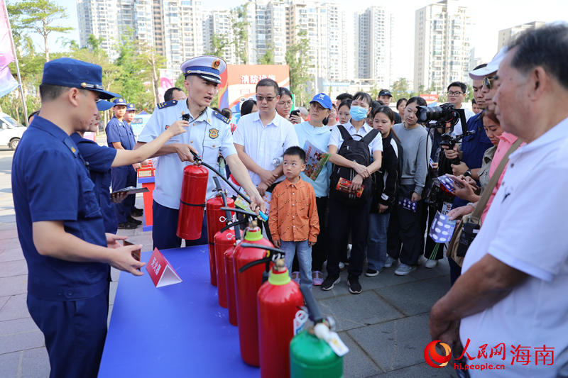 消防员向市民介绍灭火器的使用方式。 人民网记者 孟凡盛摄