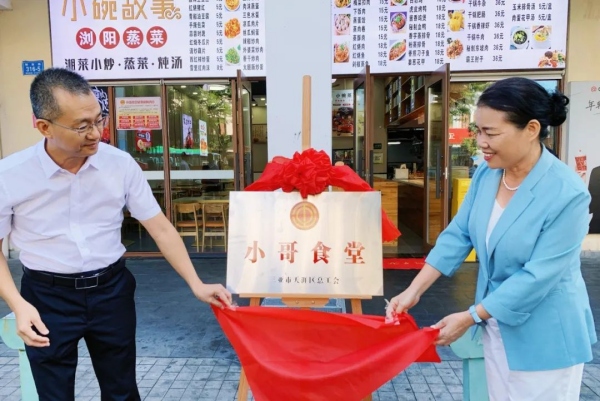 三亚市总工会党组副书记、常务副主席周月霞（右）为三亚市首批工会小哥食堂揭牌。天涯区总工会供图