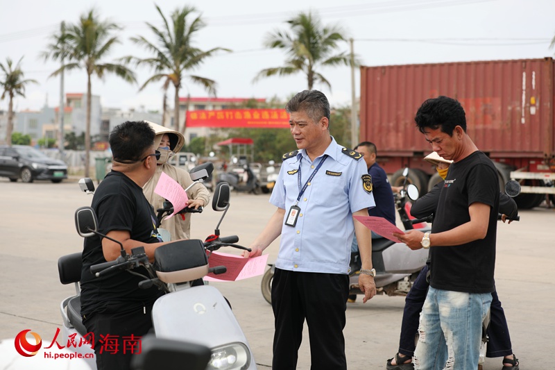 执法人员给渔民发放休渔通告。人民网记者 符武平摄