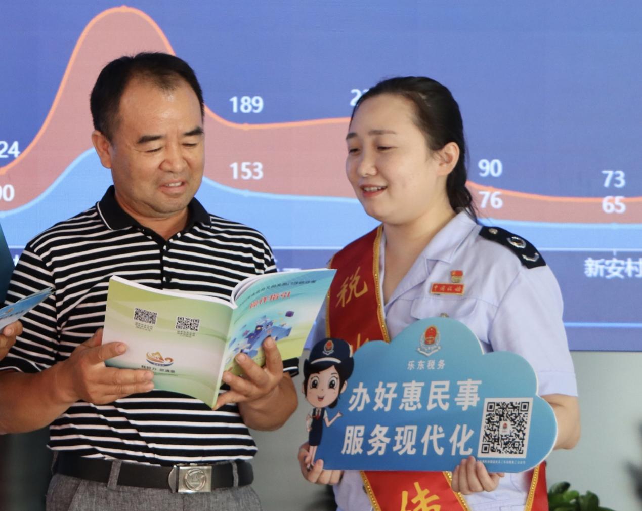 吴佳蔚在对纳税人进行税费政策辅导。潘莹摄