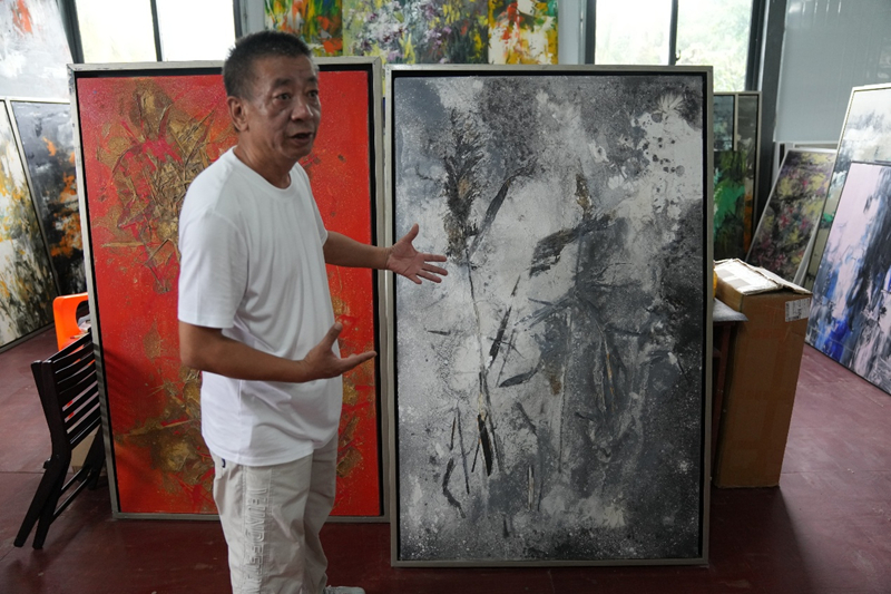 朱鲲向媒体记者介绍自己的作品。主办方供图