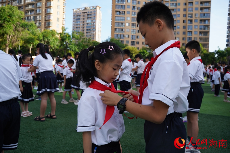 老队员为新队员系上红领巾。人民网记者 毛雷摄