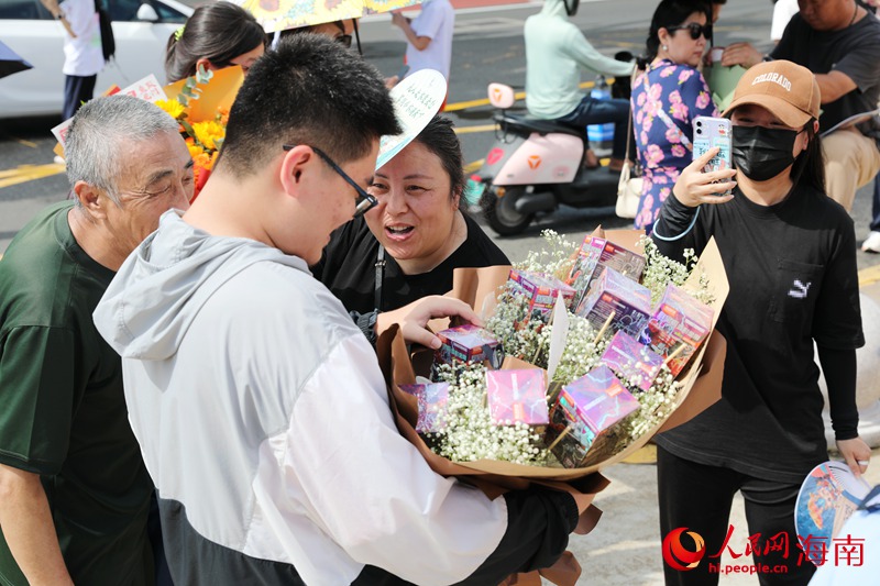 学生走出考场，家长为考生送上“盲盒鲜花”。人民网记者 符武平摄