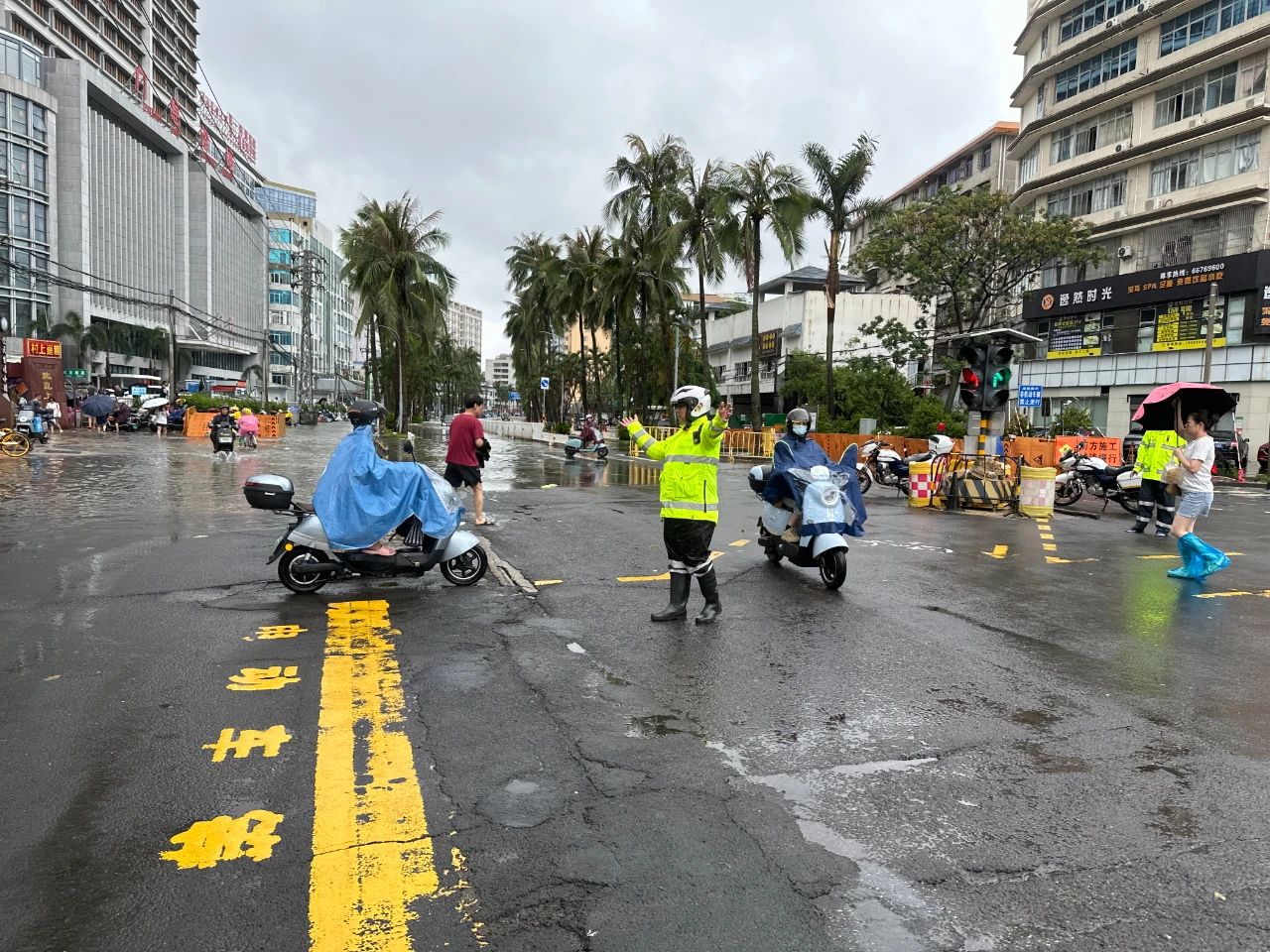 7月20日，交警龙华大队警力在龙华路积水路口疏导，劝导车辆绕行远离积水区域。 海口公安交警供图