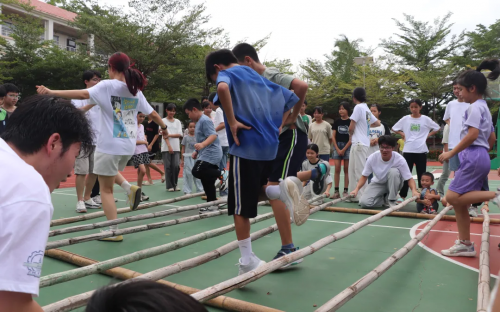 哈工大师生与槟榔村小朋友共跳竹竿舞。主办方供图