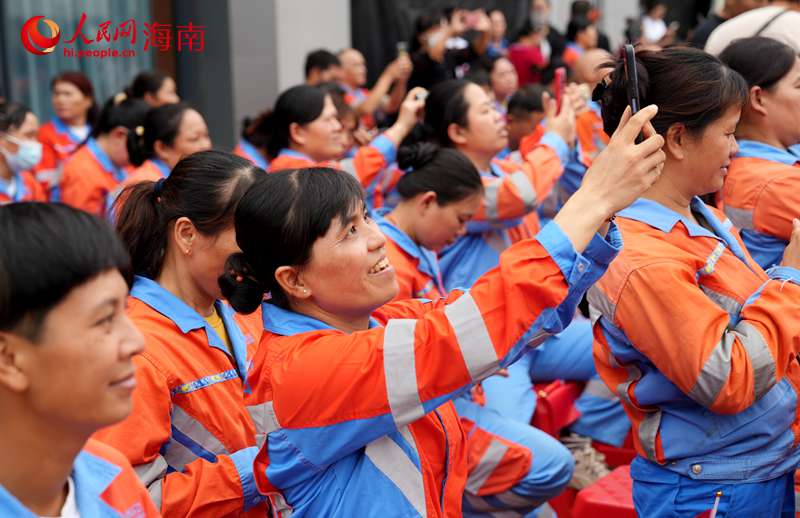 环卫工人用手机记录现场欢乐氛围。人民网记者 符武平摄