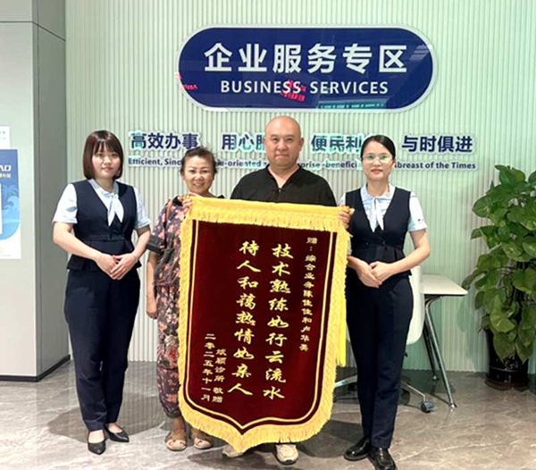 三亚斌颖医疗有限公司负责人将锦旗送到崖州区政务服务中心综合窗口工作人员手中。崖州区政务服务中心供图