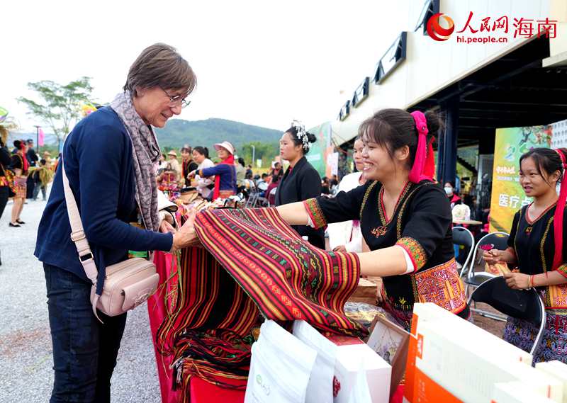 当地黎族阿妹向外宾展示黎锦。人民网记者 符武平摄