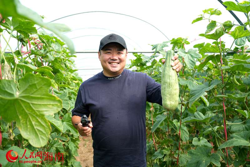 文旅博主“崔晨曦爱瞎玩”在瓜地现场吃瓜。人民网记者 符武平摄