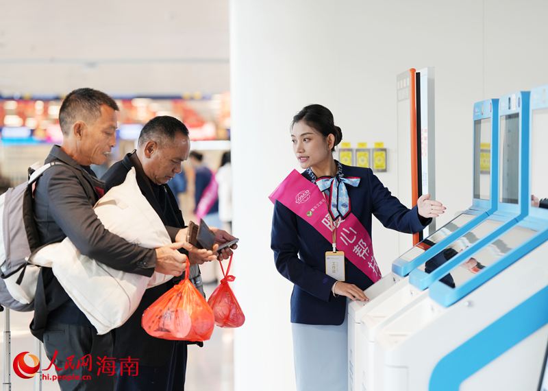 2月2日，在海口新海港，工作人员帮助旅客购票。人民网记者 符武平摄