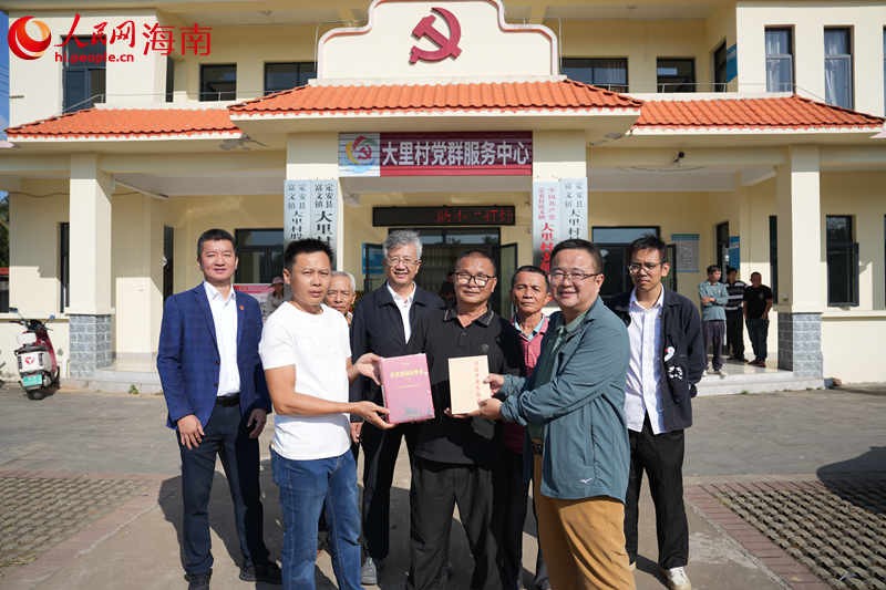 活动参与人员向大里村委会赠送相关法律书籍。人民网记者 孟凡盛摄