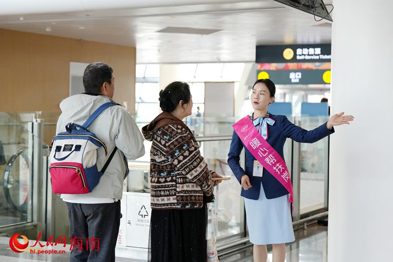 工作人员在现在为出行旅客做好服务。人民网记者 符武平摄