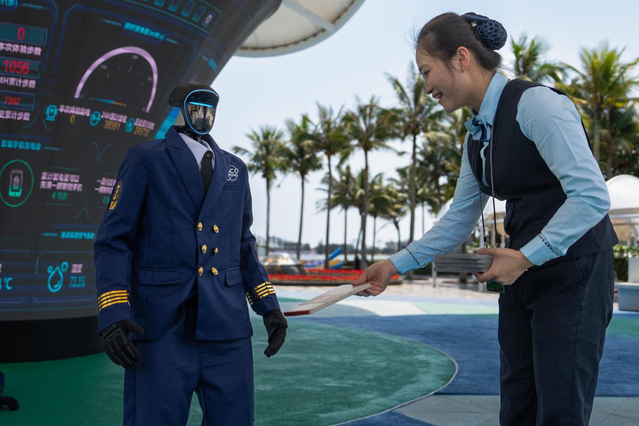 邮政工作人员与服务博鳌年会现场的智能机器人互动（陈师摄）