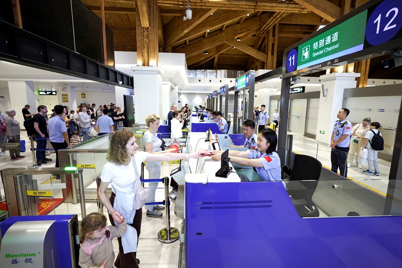 执勤民警为入境旅客办理边检手续。蒙绪顺摄