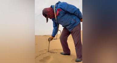 治沙人在沙漠腹地用水冲法种树