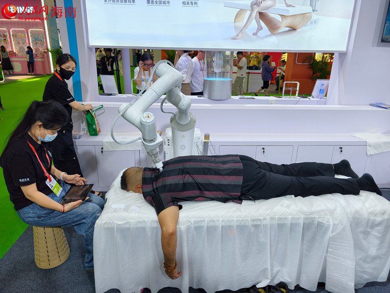 AI赋能智慧健康管理，第六届消博会现场，观众体验智能按摩机器人。人民网 符泽民摄