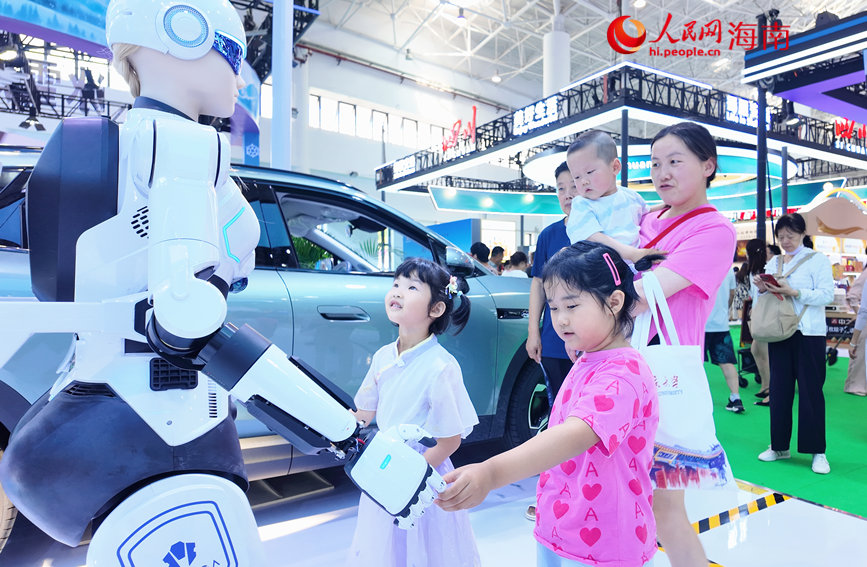 4月16日，小观众在第六届消博会展馆中与机器人互动。人民网 刘杨摄