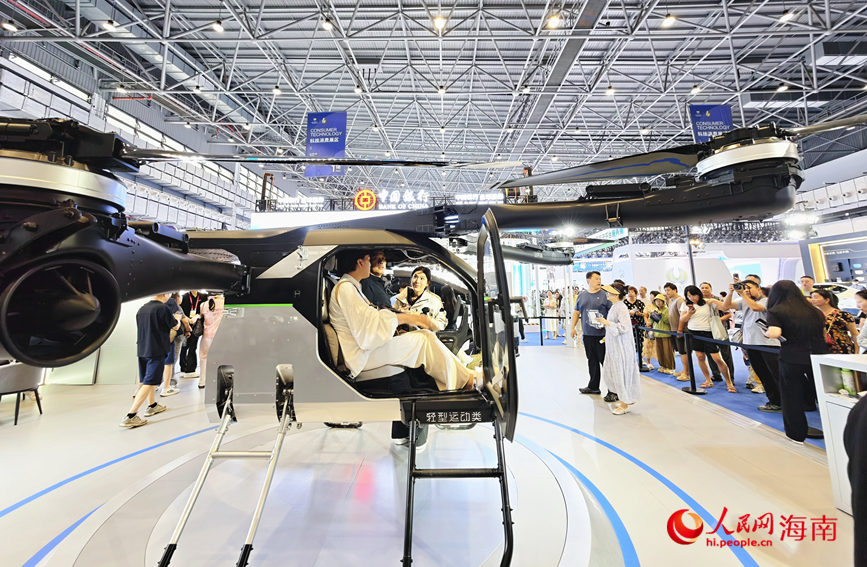 4月16日，参观者在第六届消博会科技消费展区体验全球首款陆空两栖分体式飞行汽车“陆地航母”。人民网 符泽民摄