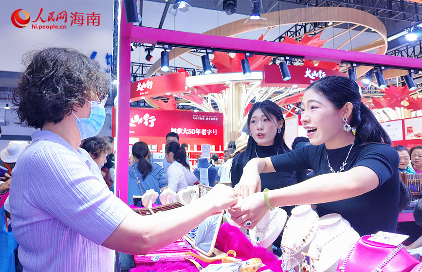 展商在第六届消博会上配合观众试戴首饰。人民网 刘杨摄