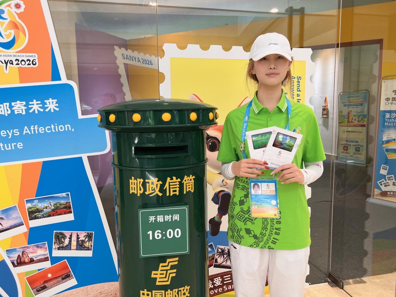 志愿者李越满是欢喜地分享心仪的纪念品。吴丹摄