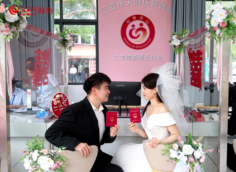 天涯区依托椰梦长廊滨海风光举办“爱在海南，心动告白”集体颁证仪式。人民网 熊淑婷摄