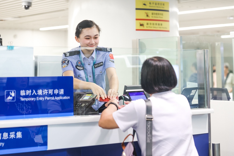 执勤民警为入境旅客办理边检手续。孙浩戎摄