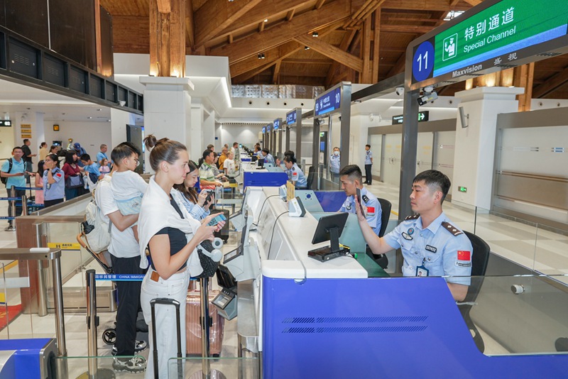 执勤民警为旅客办理入境手续。 蒙绪顺摄