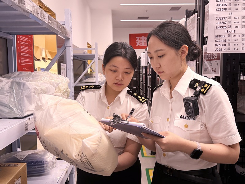 海关关员查看免税品配送情况。海口海关供图