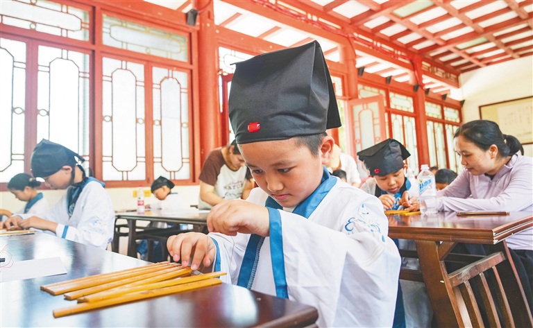 儋州东坡书院首期暑期非遗研学课堂上，孩子尝试制作竹简。海南日报全媒体记者 陈元才 摄