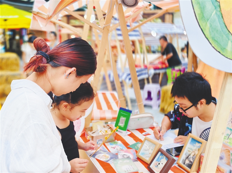 10月3日，海口日月广场一位手绘文创摊位摊主为顾客作画。海南日报全媒体记者 陈明艳 摄