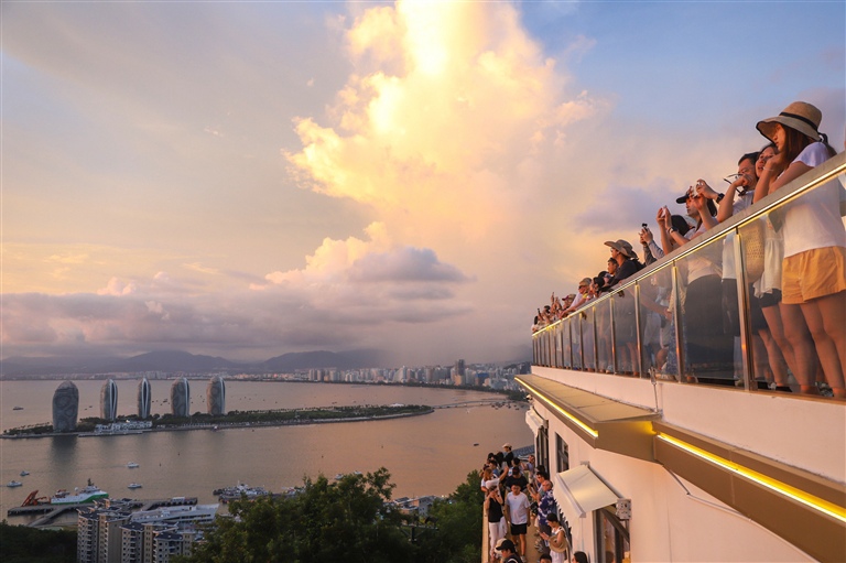 近日，游客来到鹿回头风景区欣赏三亚湾的海上晚霞。海南日报全媒体记者 王程龙 摄